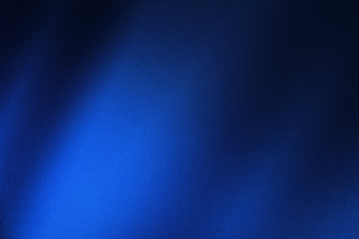 Black dark cobalt blue silk satin. Silky shiny fabric. Beautiful elegant background. Light shadow glow shimmer shine gradient.
