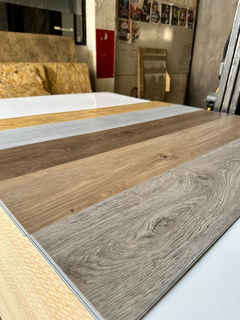 Display of various wood and laminate flooring samples showing different wood grain patterns and finishes